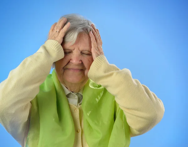 Senior mujer preocupada contra fondo azul . — Foto de Stock