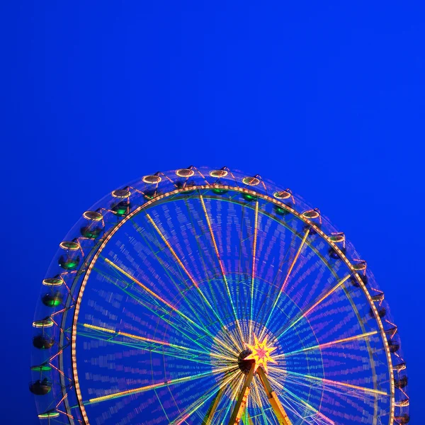 Carrousel. Reuzenrad op een blauwe achtergrond. lange tijd van blootstelling. — Stockfoto
