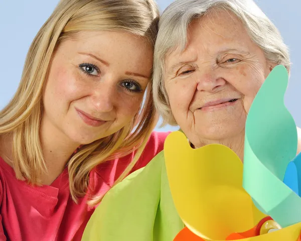 Child and grandchild give a gift senior woman. — Stock Photo, Image