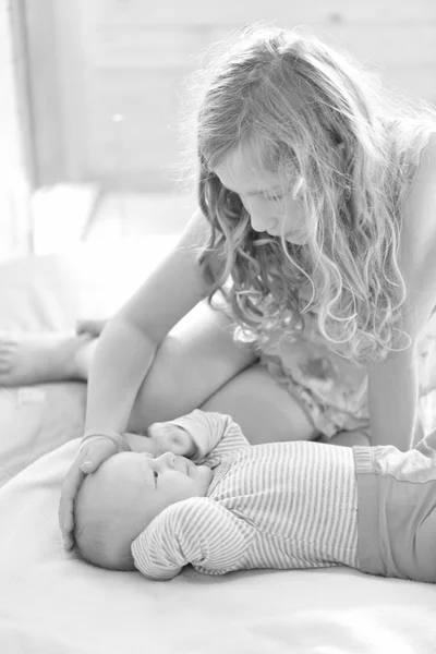 Hermana mayor cuidando a la menor. Blanco y negro . — Foto de Stock