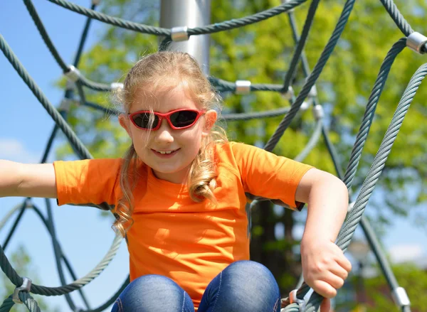 Girl climbing up the ropes. — Stock Photo, Image