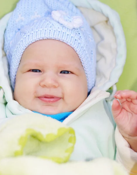 Bebê bonito está em um carrinho e olhando para a câmera . — Fotografia de Stock