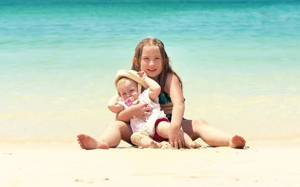 Systrar som sitter på stranden — Stockfoto