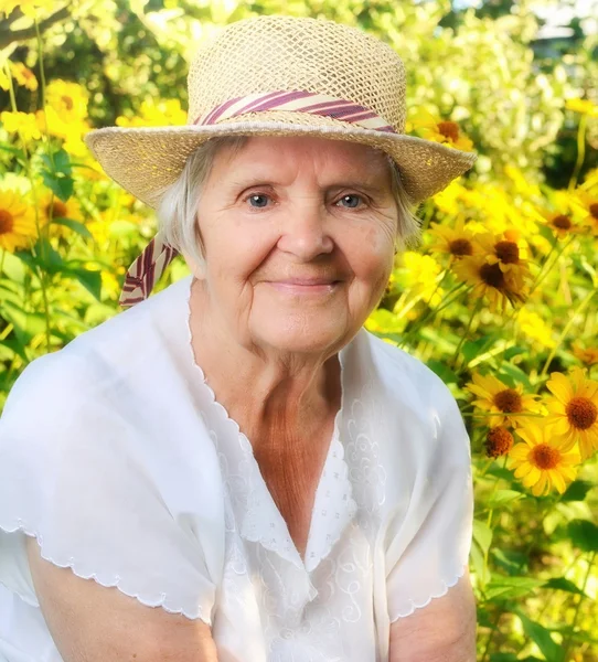 Старшая женщина в саду, полном цветов . — стоковое фото