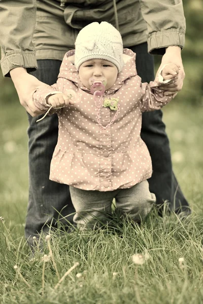 Baby learns to walk in the grass. — Stock Photo, Image