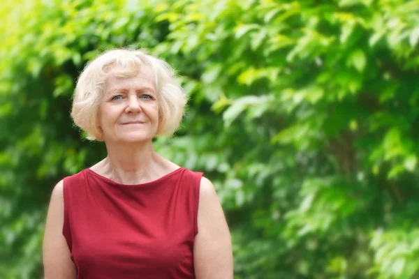 Mature, blonde woman in garden, — Stock Photo, Image