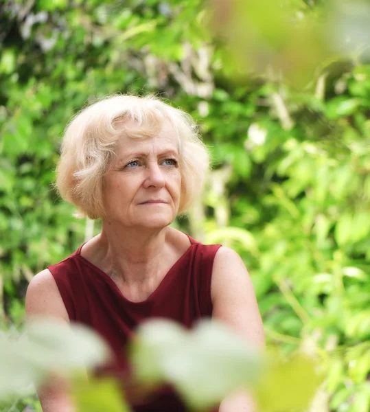 Mature, blonde woman in garden, — Stock Photo, Image