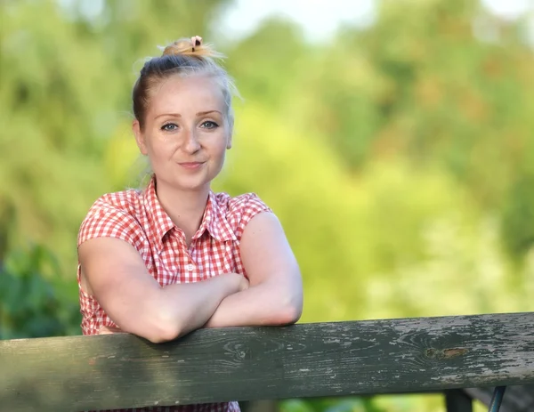 Jeune femme attrayante debout sur une terrasse en bois . — Photo