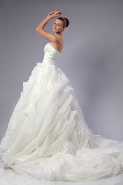 gri bir arka plan üzerinde bir gelinlikle güzel kız