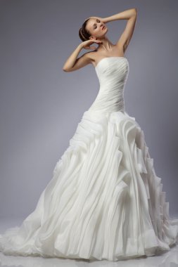 gri bir arka plan üzerinde bir gelinlikle güzel kız