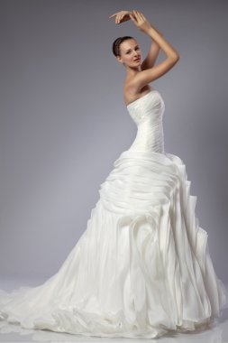 gri bir arka plan üzerinde bir gelinlikle güzel kız