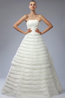 gri bir arka plan üzerinde bir gelinlikle güzel kız