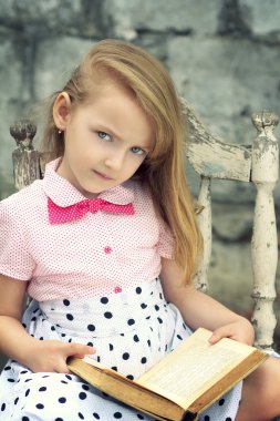 elinde bir kitapla ciddi küçük kız