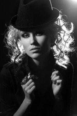 şapkalı güzel sarışın kız portresi. siyah zemin ışık zıt fingerin üzerinde olağandışı bir yüzükle