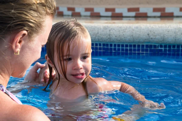 Moeder en dochter speelse in het zwembad — Stockfoto