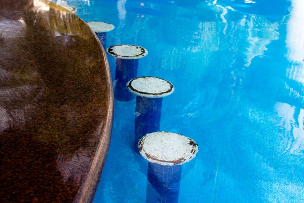 Барные сиденья у бассейна с гранитной столешницей — стоковое фото