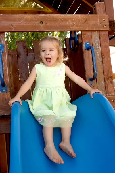 Dois anos de idade menina cumprida no slide — Fotografia de Stock