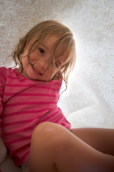 Playful little girl under a white blanket — Stock Photo, Image