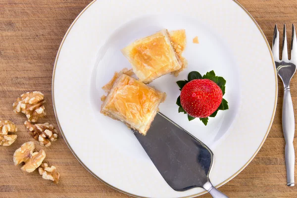 Baklava servi avec spatule sur planche à découper en bambou — Photo