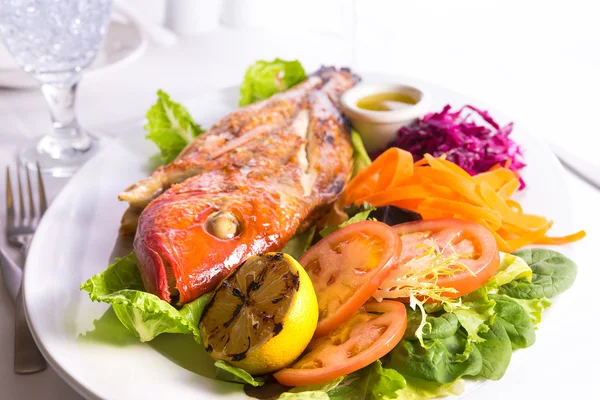 Volledige gekookte tilapia geserveerd met groenten en vis saus departement — Stockfoto