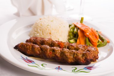 Adana kebap sebze ile süslenmiş bir lavaş ekmeği servis