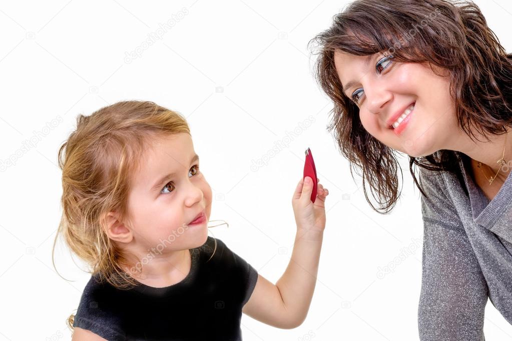 Cute little girl wants to apply her mothers makeup