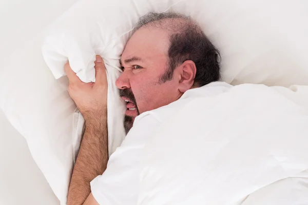 Insomnio agarrándose a su almohada desesperado — Foto de Stock