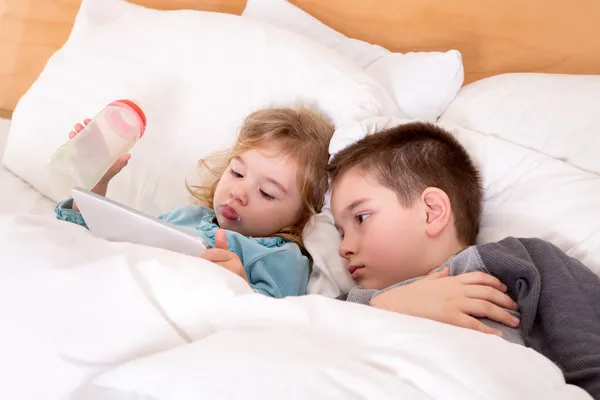 Schattige kleine jongen en meisje lezen voordat slapen — Stockfoto