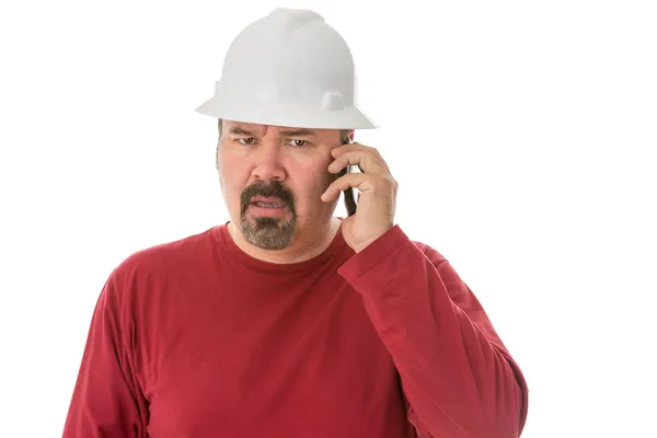 Workman ser förvirrad talar på en mobil — Stockfoto