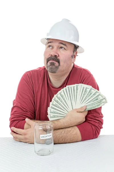 Unhappy construction worker holding to tax money — Stock Photo, Image