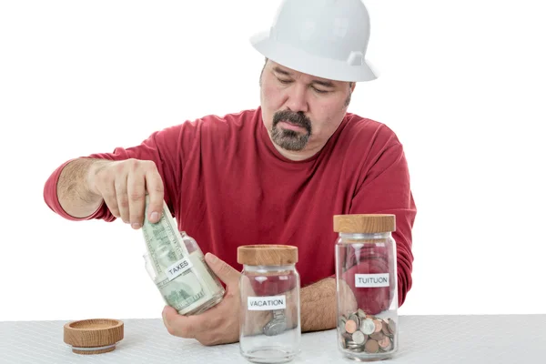 Unhappy construction worker paying the taxes — Stock Photo, Image