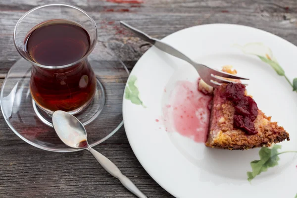 Bit av läcker ostkaka med turkiskt te — Stockfoto