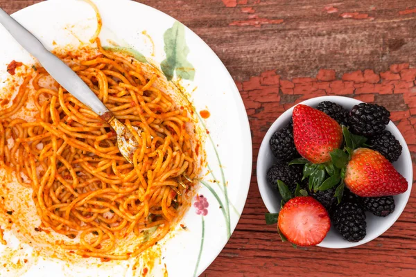 Спагетти Болоньезе и ягодный десерт — стоковое фото