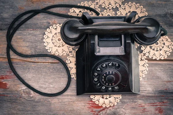 Old rotary phone on a decorative criocheted doily — Stok Foto