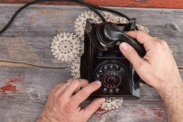 Homme composant sur un vieux téléphone rotatif — Photo