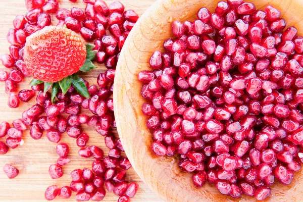 Pomegranate seeds with a strawberry — Stock Photo, Image