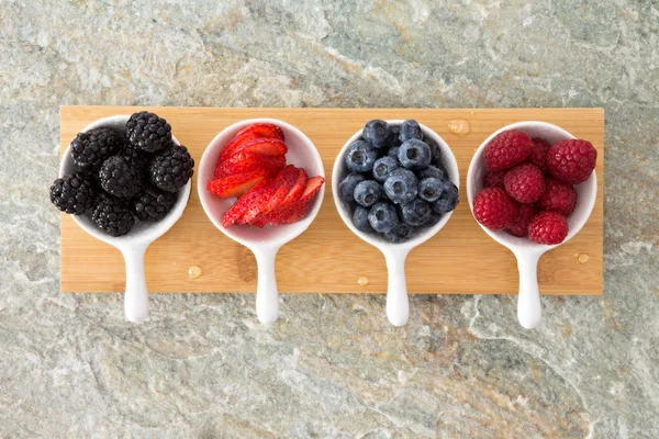 Assorted fresh berries in taster dishes — Stock Photo, Image