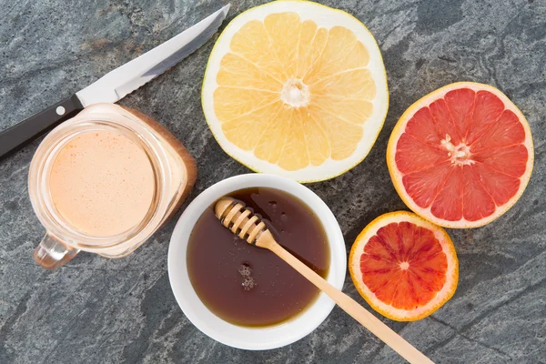 Färsk grapefrukt och juice serveras med honung — Stockfoto