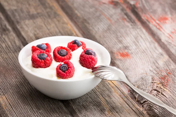 Frische Himbeeren und Blaubeeren mit Joghurt — Stockfoto