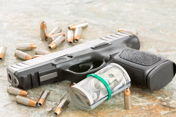Handgun with money and scattered bullets — Stock Photo, Image