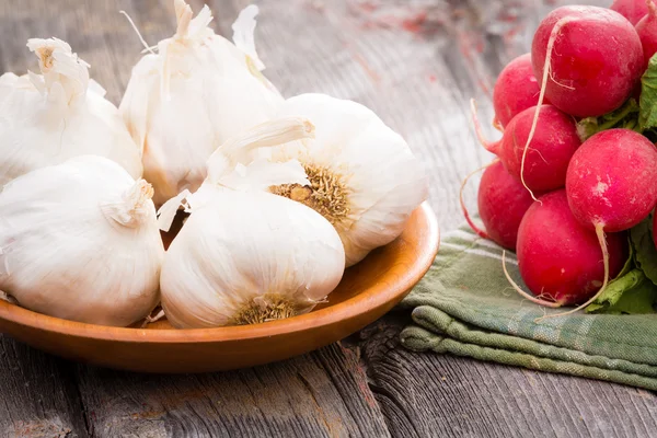 Fresh whole garlic bulbs with radishes — Stock Photo, Image