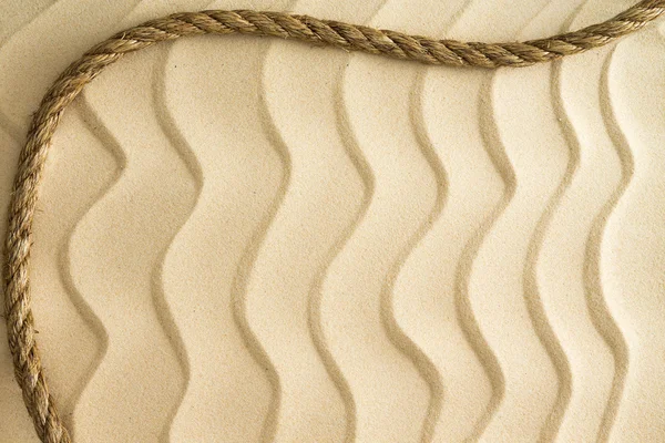 Nautical background of wavy sand with a rope — Stock Photo, Image