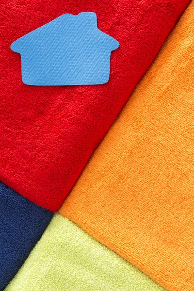 Vivid geometric pattern of towels with a home icon — Stock Photo, Image