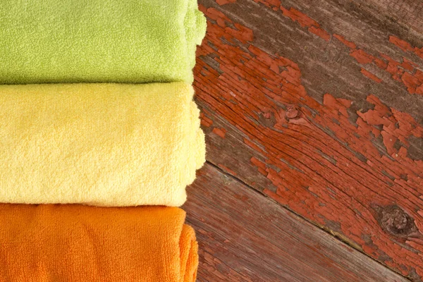 Fresh clean green, yellow and orange towels — Stock Photo, Image