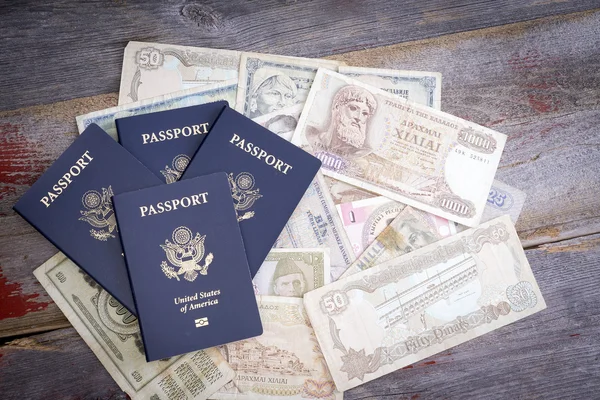 Group of American passports with foreign banknotes — Stock Photo, Image