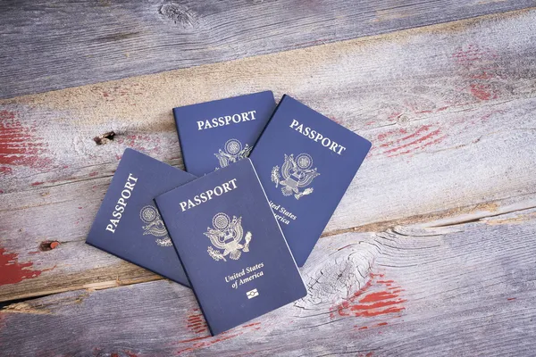 Quatro passaportes dos Estados Unidos em uma mesa de madeira — Fotografia de Stock