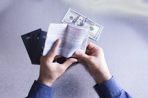 Hombre comprobando los detalles de un pasaporte — Foto de Stock