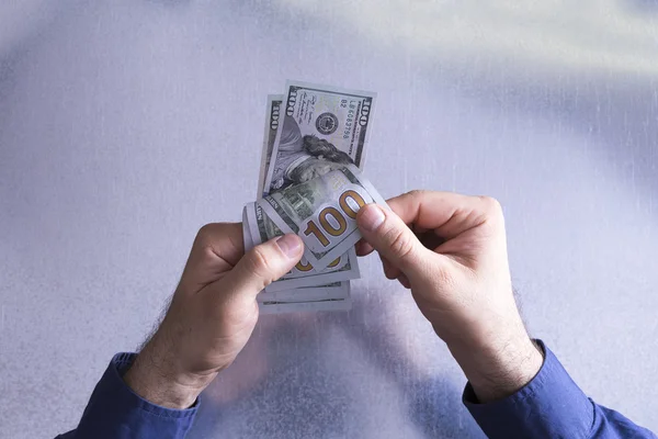 Homem contando ou pagando notas de 100 dólares — Fotografia de Stock