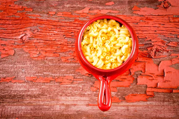 Kids cheese macaroni in clay pot on rustic table — Stock Photo, Image