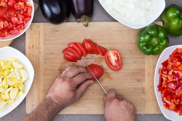 Человек готовит овощи на кухне — стоковое фото